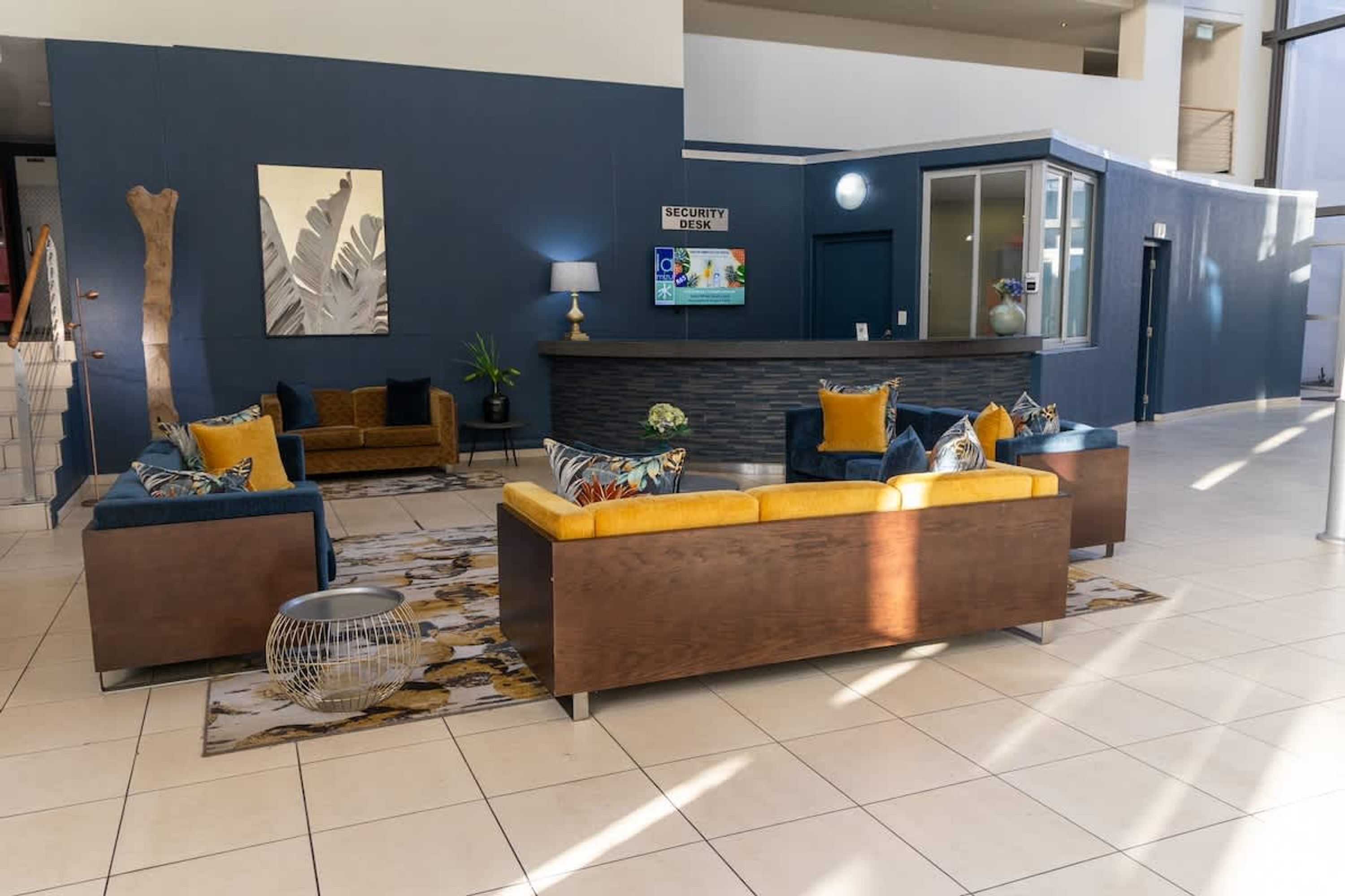 A modern lobby with a reception desk, seating area, and artwork on the walls.