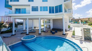 Un hotel moderno con piscina, area salotto all'aperto e patio coperto.