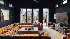Uma sala de estar moderna com um amplo sofá modular, uma mesa de centro e uma televisão.