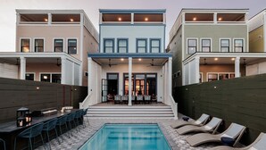 Uma casa moderna de dois andares com piscina, área de estar externa e varanda coberta.
