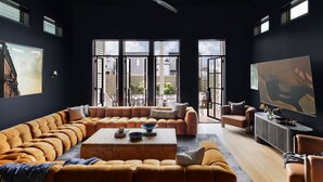 Een moderne woonkamer met een grote hoekbank, een salontafel en een televisie.