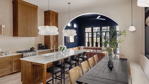 Una cocina moderna con una isla central, armarios de madera e iluminación colgante.