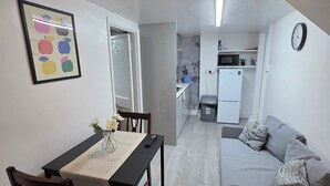 Una cocina moderna con armarios blancos, un microondas y un reloj en la pared.