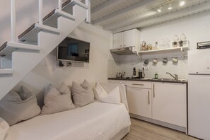 A modern kitchen with white cabinets, a built-in oven, and a countertop with various kitchen items.
