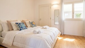 A bedroom with a bed, pillows, a mirror, and a window. - Maison Aurora+ Pivate Parking Space (Bari)