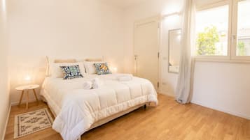 Una camera da letto con un letto, un comodino e una finestra con tende.