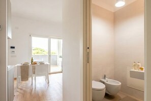 A modern bathroom with a toilet, bidet, and a small sink.