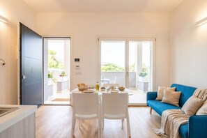 Een modern interieur met een eethoek, een blauwe bank en een keukenblad.