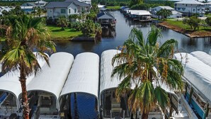 Ein Yachthafen mit mehreren angedockten Booten, umgeben von Palmen und Häusern.