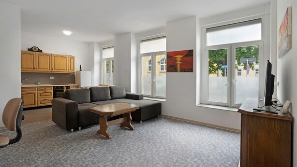 A modern living room with a sofa, a coffee table, and a TV stand.