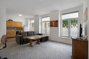 Una sala de estar moderna con un sofá, una mesa de centro y un mueble para televisión.