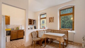 Una cocina con comedor, armarios de madera, un banco empotrado y una ventana con vistas.