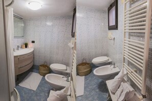 A bathroom with a white sink, two toilets, a bidet, and a mirror. - Mare Tra i Tetti -  The sea among the rooftops (Monopoli)