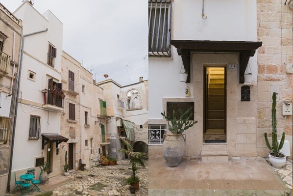 A narrow street with buildings on either side, a cobblestone path, and a door with a number 7 sign. - Mare Tra i Tetti -  The sea among the rooftops (Monopoli)