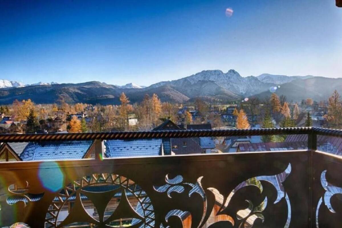 Ein Balkon mit Blick auf eine Berglandschaft und ein Dorf darunter.