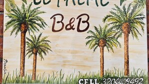 A sign with palm trees and the text "LE PALME B&B" along with a phone number.