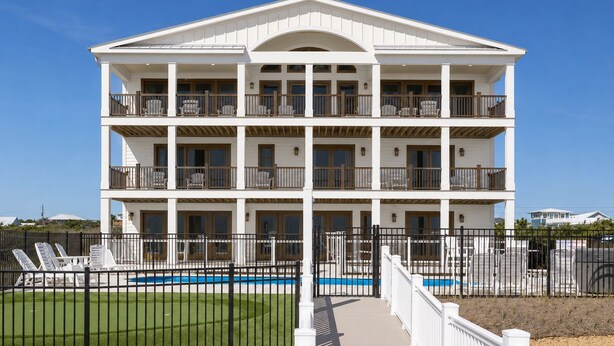 Um edifício com várias andares, varandas, piscina e área cercada com espreguiçadeiras.