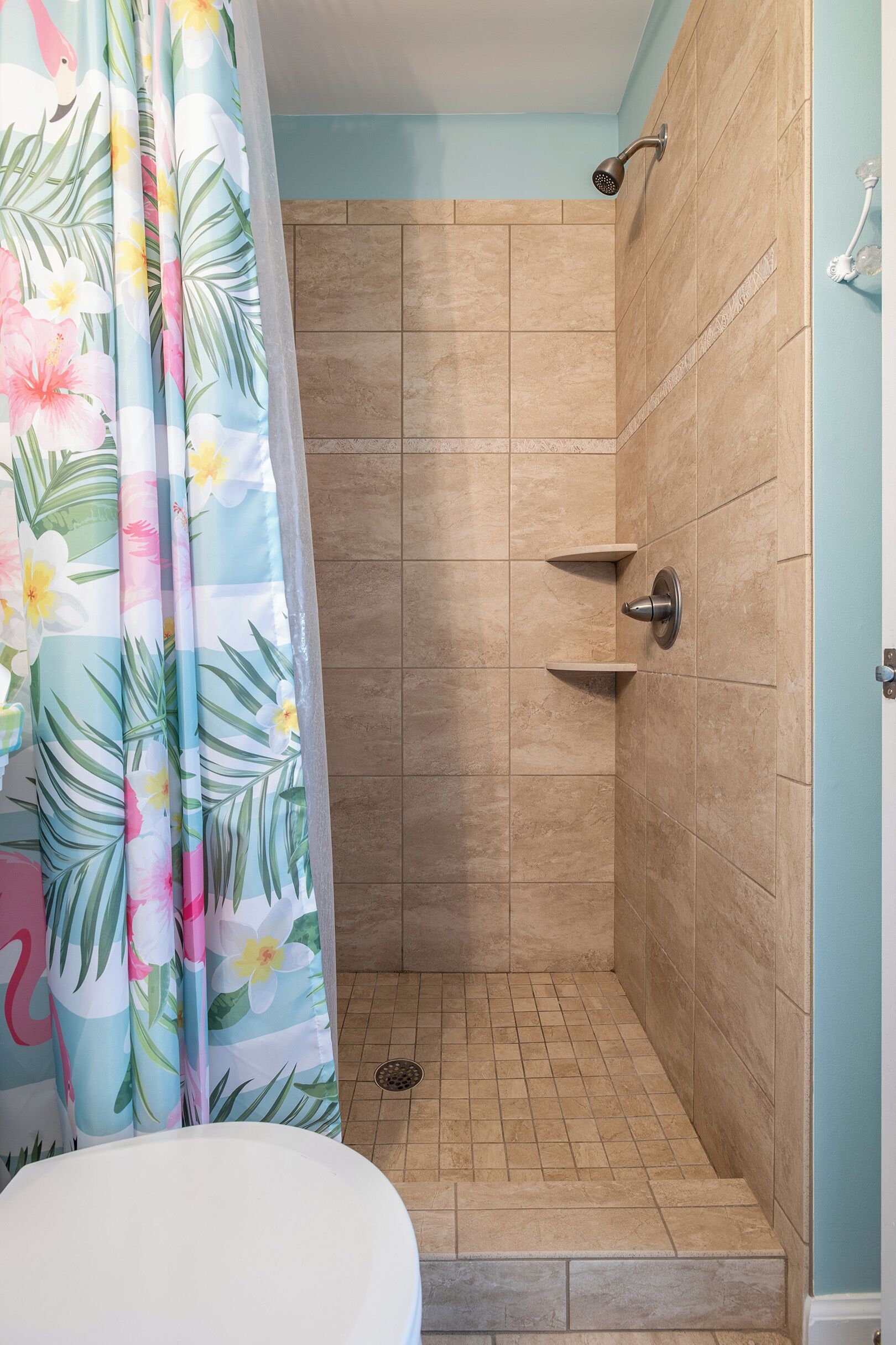 A shower area with a tiled floor and a showerhead.