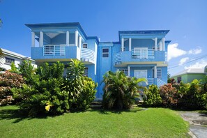 A two-story building with balconies and a well-maintained lawn. - Best E Villas St. Silas (Deanes)