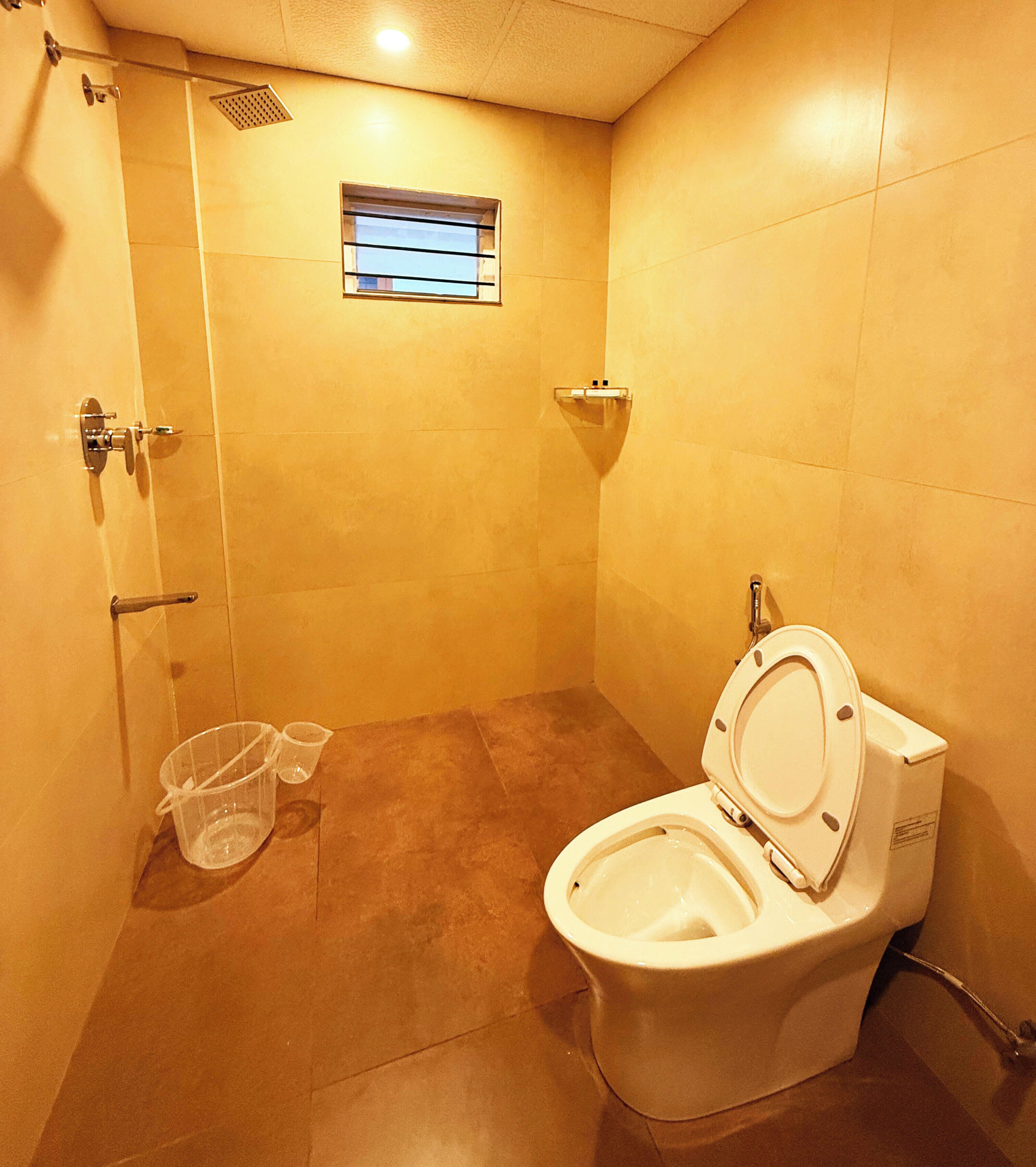 Un ba ño pequeño con ducha, inodoro y una ventana.