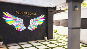 Un edificio moderno con un logotipo que presenta alas coloridas y el texto "PEPPER COAST EDAPPALLY".