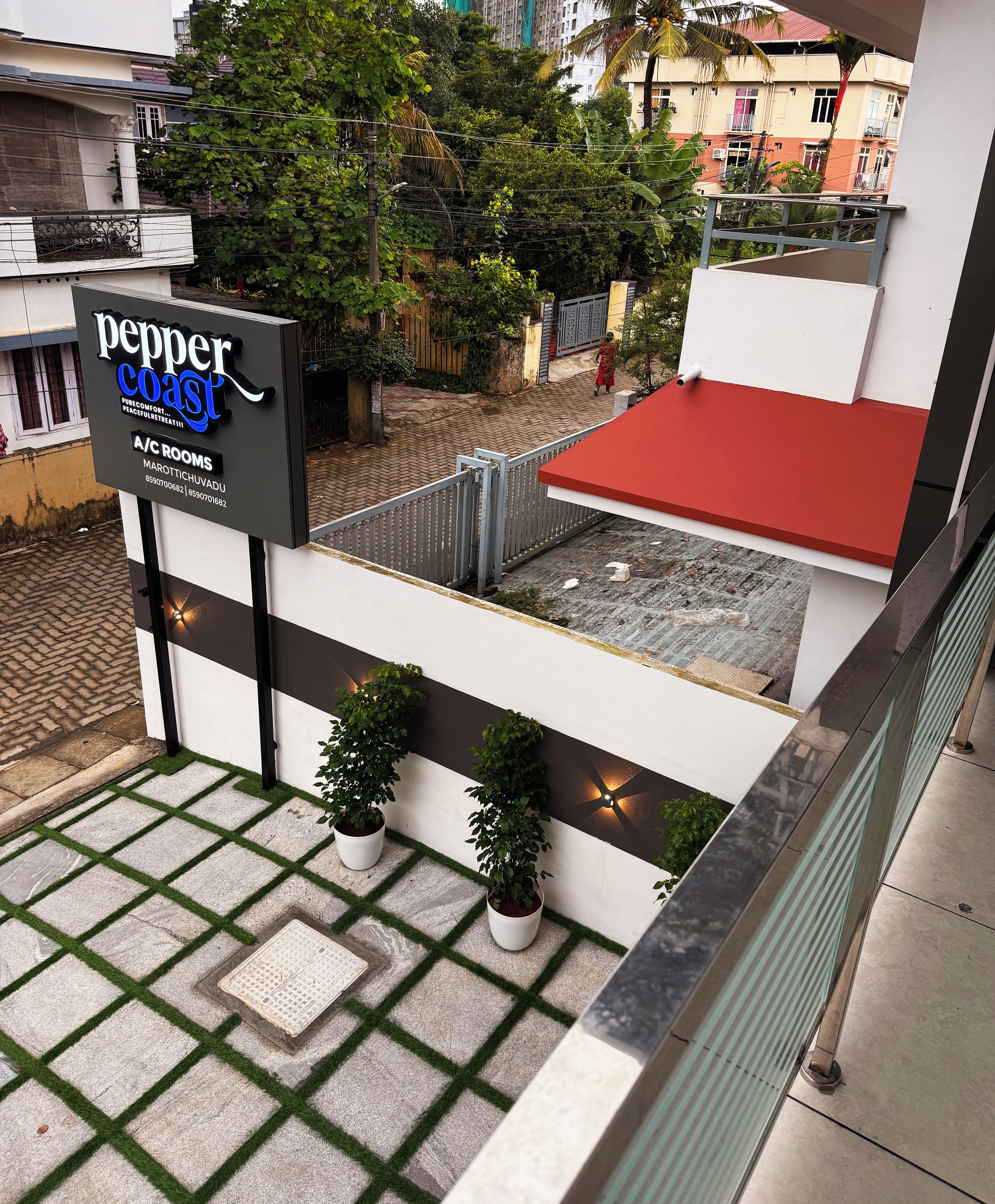 A hotel sign with "pepper coast" and "A/C rooms" indicating amenities.