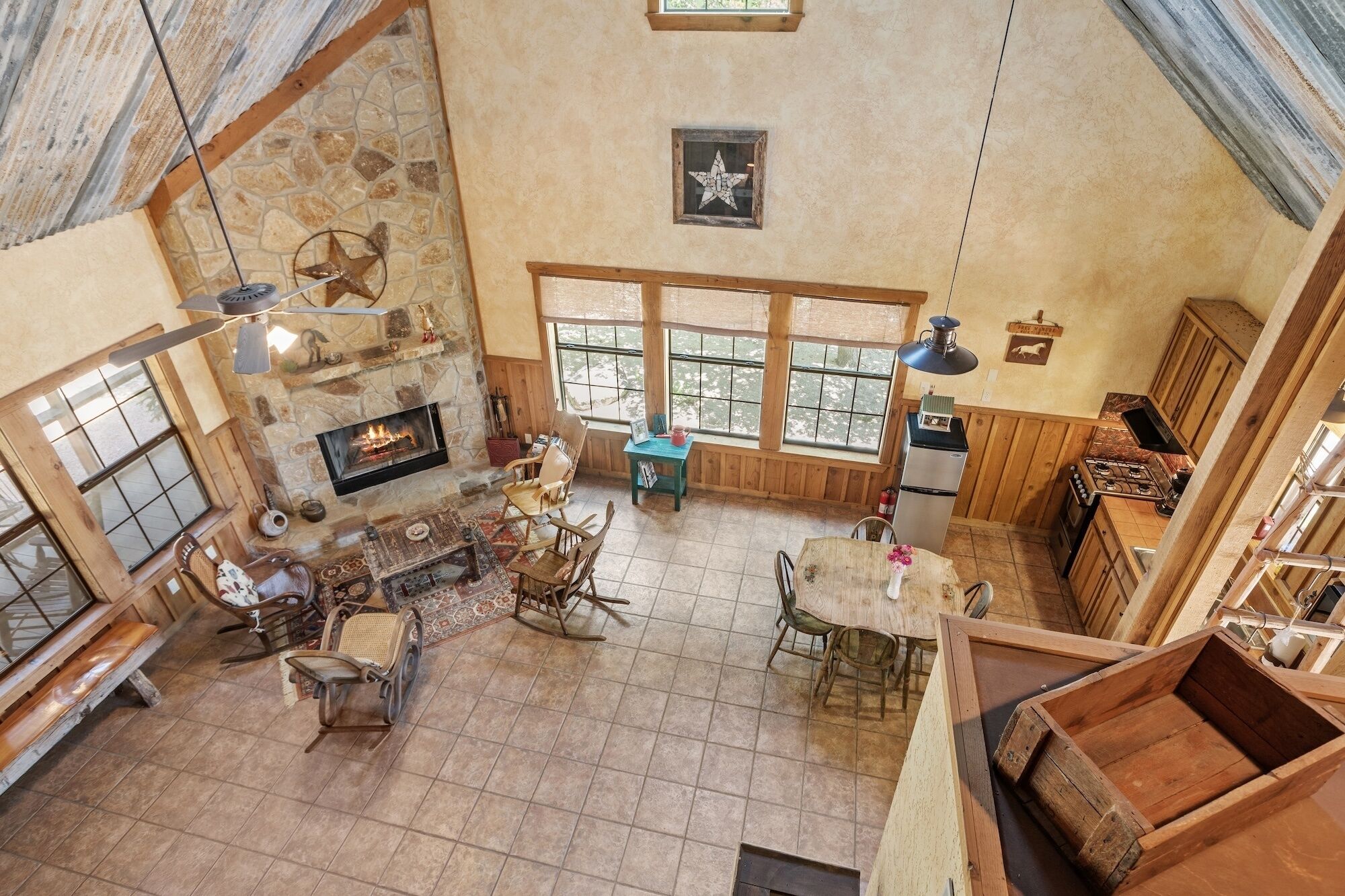 En rummelig opholdsstue med pejs, træmøbler og store vinduer.