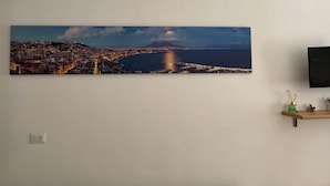 Une vue urbaine comprenant un front de mer, un pont et une montagne à l’horizon.