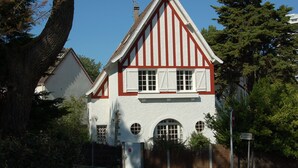 A traditional building with a white facade and red trim, featuring a gabled roof and arched windows. - Villa La Baule les pins between Aquabaule and the beach (La Baule-Escoublac)