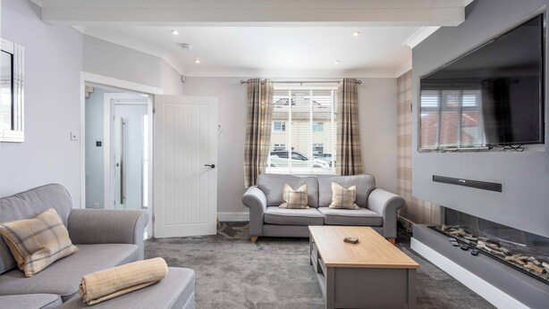 Een moderne woonkamer met twee banken, een salontafel en een open haard.