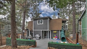 A two-story house with a patio area, a grill, and a slide. - Game On Getaway: Slide & Sleeps 6 (Big Bear Lake)