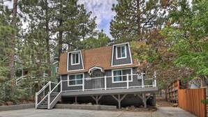 A two-story house with a balcony and a staircase leading to the entrance. - Game On Getaway: Slide & Sleeps 6 (Big Bear Lake)