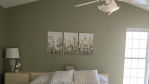 A bedroom with a bed, a nightstand, a lamp, a ceiling fan, and three wall art pieces. - Delightful 3-bedroom, 2 bath home in Savannah Lakes Village--McCormick, SC (McCormick)