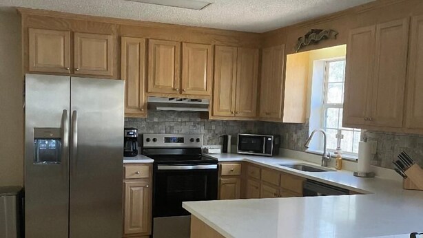 A modern kitchen with wooden cabinets, stainless steel appliances, and a central island. - Delightful 3-bedroom, 2 bath home in Savannah Lakes Village--McCormick, SC (McCormick)