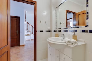 A bathroom with a sink, mirror, and wooden door. - Spacious Villa - Walk to Beach & City Center (Lagos)