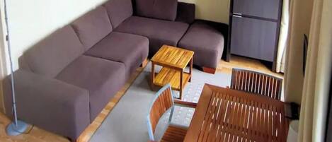 A living area with a sofa, a small wooden table, and a cabinet.