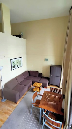 A living area with a sofa, a small wooden table, and a cabinet.