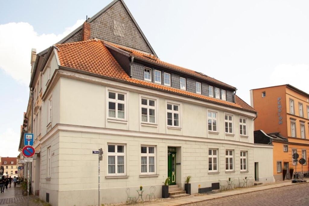 Un bâtiment à deux étages, doté d’un toit à forte pente et d’une porte verte.