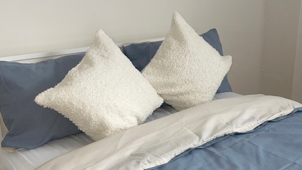 A bed with a blue and white duvet, two white pillows, and a blue pillow. - Sherwood Hideaway Retreat (Nottingham)