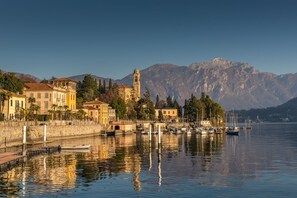 Une ville située au bord de l’eau, dotée de bâtiments historiques, d’un clocher d’église imposant et d’un port de plaisance où sont amarrés des bateaux.