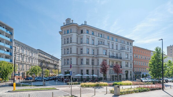 Un edificio de varios pisos con un estilo arquitectónico clásico, que destaca por una entrada central con marquesina.