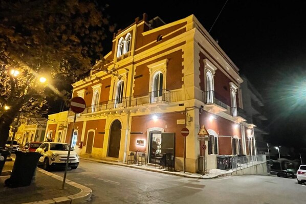 Un edificio histórico con un balcón y un restaurante en la planta baja.