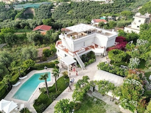 A modern multi-story building with a rooftop terrace, a swimming pool, and lush greenery surrounding the property. - Luxury Levaina Villa, Sleeps 8 on the Amalfi Coast (Positano)