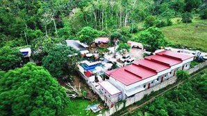 A large building with a red roof, surrounded by lush greenery and trees. - Whole Villa Exclusive Overnight Phase 1 (Balamban)