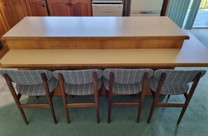A dining table with four plaid chairs and a wooden countertop. - Enjoy Sydney's Northern Beaches. Unique district views, 1950s classic, sleeps 5 (Seaforth)