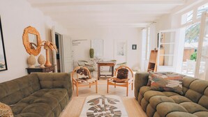 A living room with two sofas, a coffee table, and chairs. There is a door leading to a balcony. - Villa Phoenix - Ancient and modern charm (La Couarde sur mer)