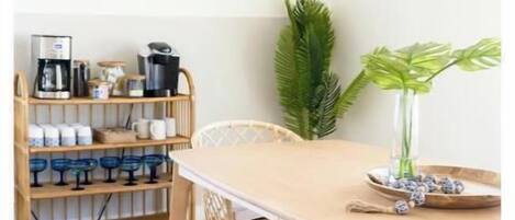 A dining area with a wooden table, bench, and hanging light fixture.
