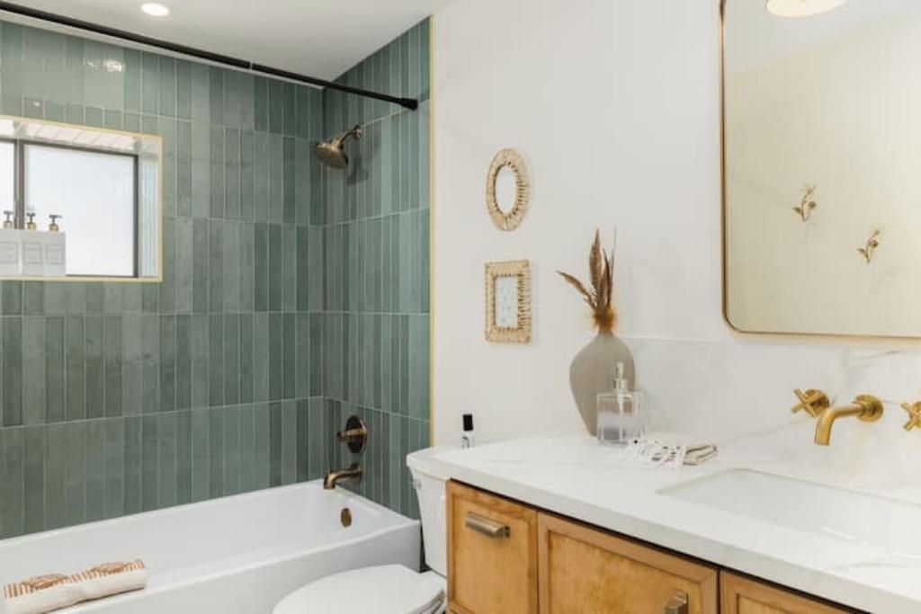 A modern bathroom with a bathtub, toilet, and sink.