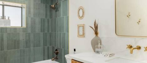 A modern bathroom with a bathtub, toilet, and sink.