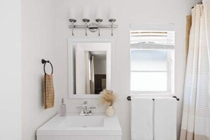 A bathroom with a white sink, mirror, and towel rack. - Walk to Old Town Scottsdale! Tulum Vibes, Pool & Hot Tub, Full Kitchen (Scottsdale)